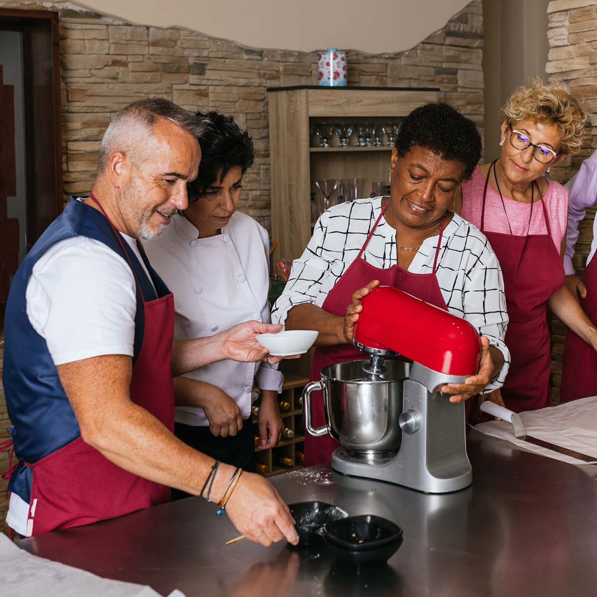 Gruppe von Menschen lernt in einem Workshop kochen.