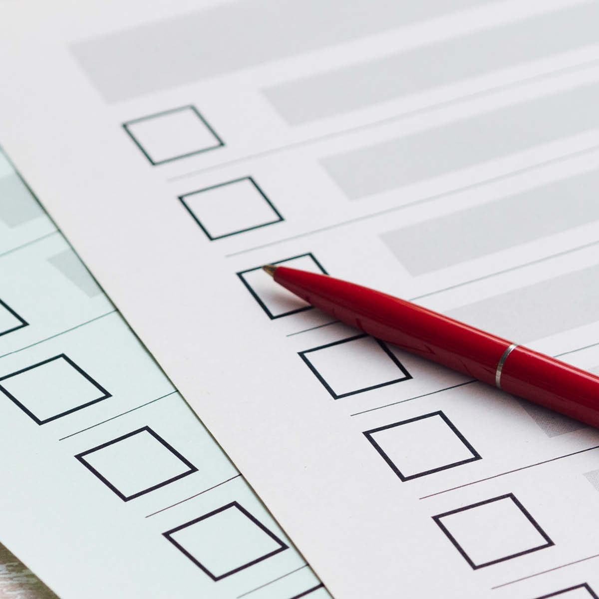 Umfragebogen nach Events und Workshops, auf denen ein roter Kugelschreiber liegt.