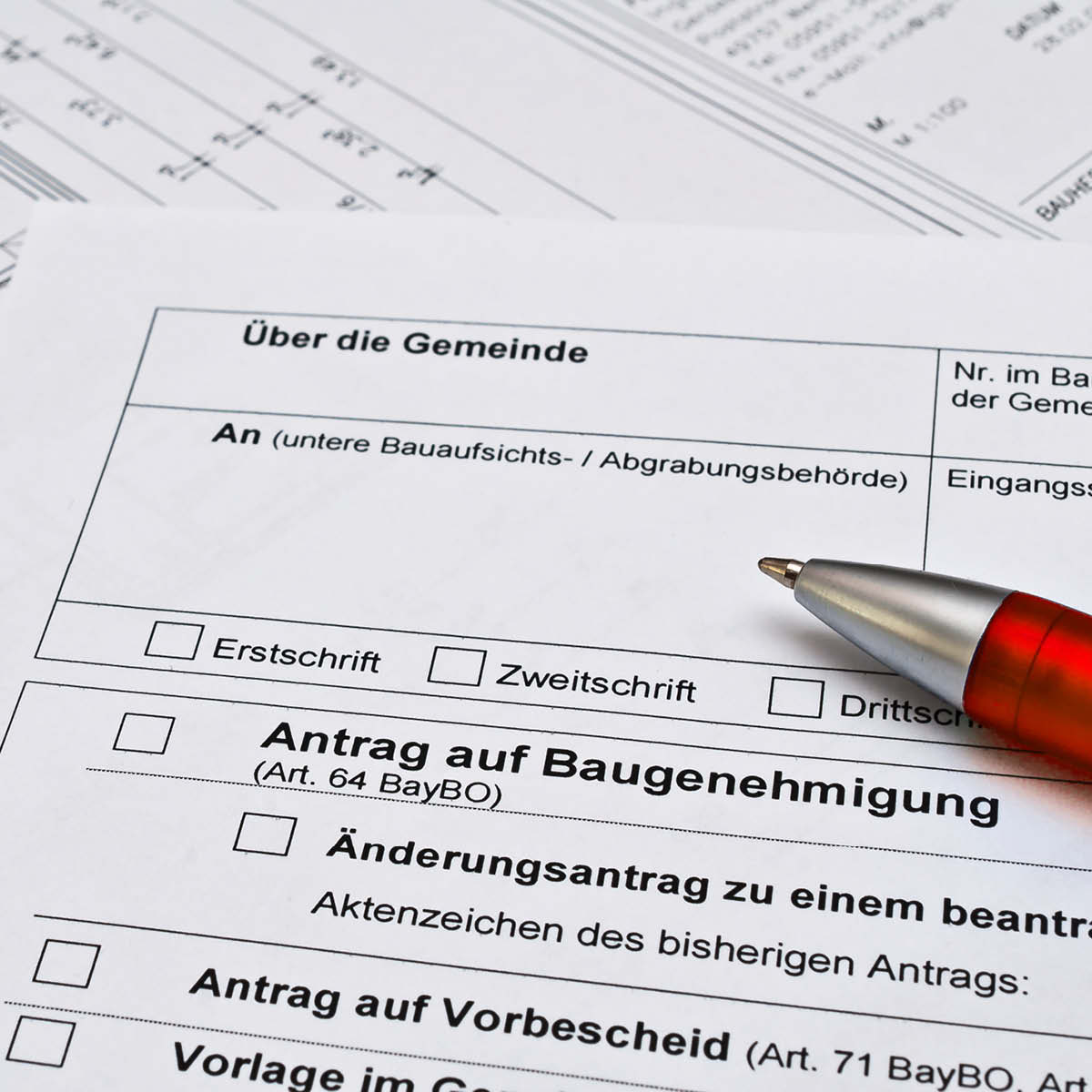 Umbauphasen als Verkaufschance: Baugenehmigung von der Gemeinde mit rotem Kugelschreiber.