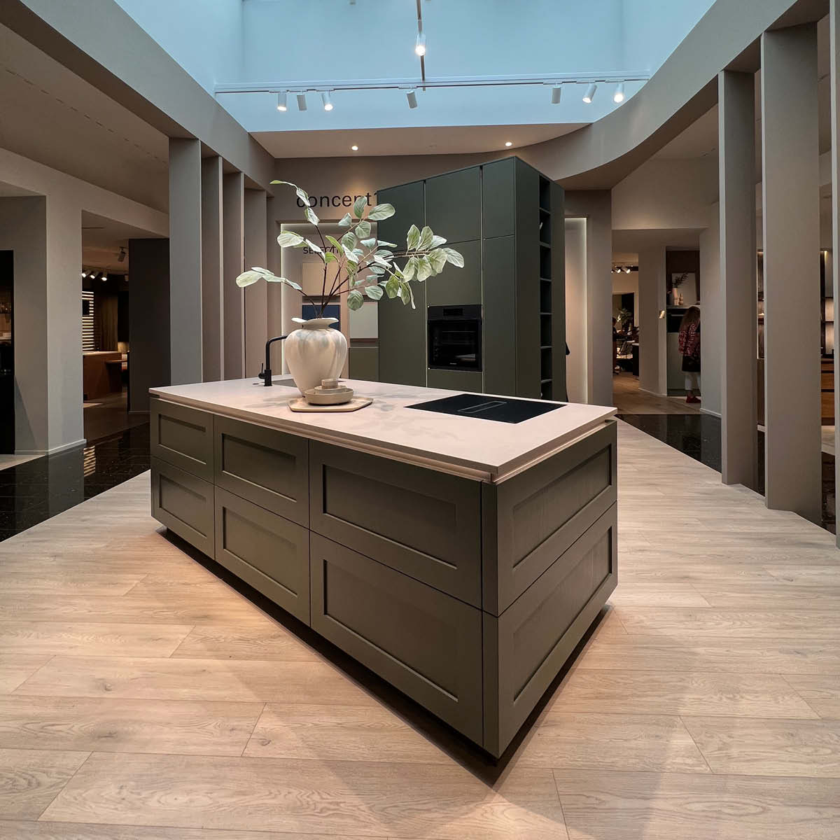 Moderne Kochinsel im Landhausstil in dunkelgrün.