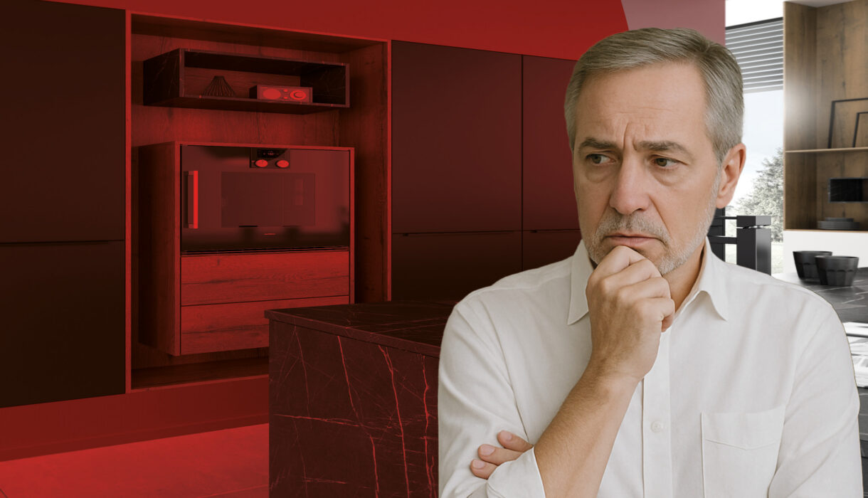 Nachdenklicher Unternehmer vor moderner Küche – Symbol für die Herausforderungen und Chancen der Unternehmensnachfolge im Küchenhandel.