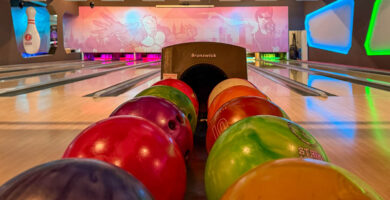 Mehrere bunte Bowlingkugeln in einer Bowlingbahn