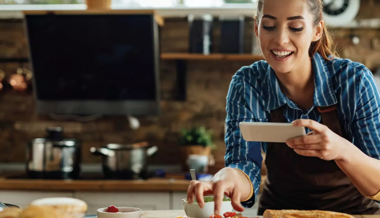 Frau fotografiert frisch belegte Brötchen in einer modernen Küche – Genuss, Kreativität und Leidenschaft fürs Kochen mit Der Küchenring.