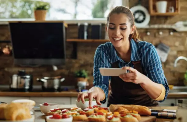 Frau fotografiert frisch belegte Brötchen in einer modernen Küche – Genuss, Kreativität und Leidenschaft fürs Kochen mit Der Küchenring.